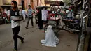 Seorang wanita mengemis di pinggir jalan di tempat-tempat tua di New Delhi, India, Rabu (10/10). Banyak warga miskin India bermigrasi ke kota-kota besar untuk mencari pekerjaan. (AP Photo / R S Iyer)