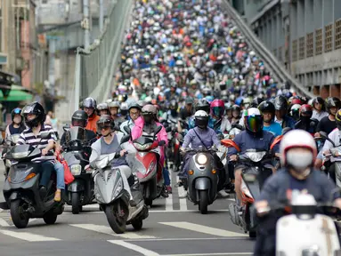 Pengendara sepeda motor melintasi Jembatan Taipei pada jam sibuk pagi hari, China (21/5). Sebelumnya telah beredar sebuah video mengejutkan mengenai kondisi sebuah jalan yang dipenuhi oleh antrean motor. (AFP Photo/Chris Stowers)