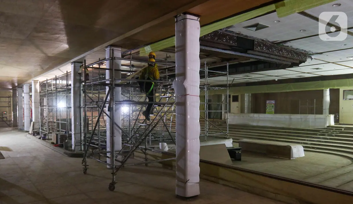 Pekerja menyelesaikan revitalisasi panggung Sasana Kriya di Taman Mini Indonesia Indah (TMII), Jakarta Timur, Selasa (12/7/2022). Progres revitalisasi Taman Mini Indonesia Indah (TMII) secara fisik telah mencapai sekitar 70 hingga 80 persen dan ditargetkan rampung bulan ini. (Liputan6.com/Herman Zakharia)