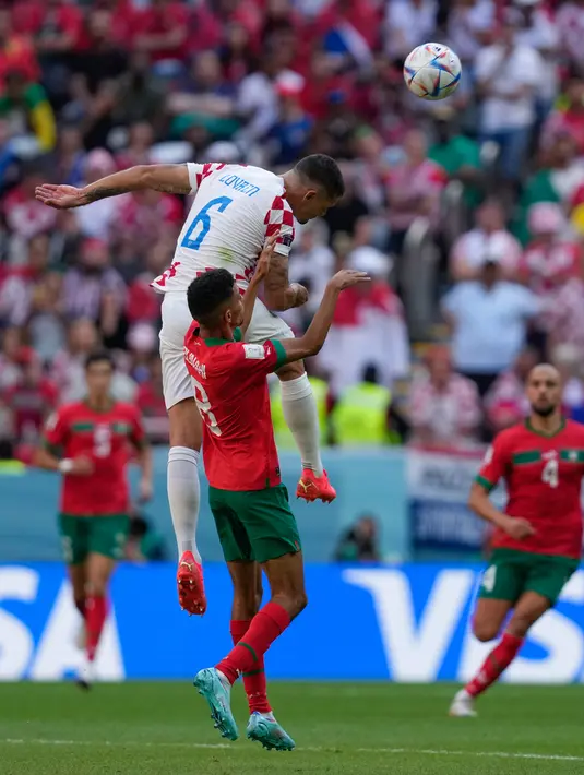 Pemain Kroasia Dejan Lovren (atas) melompati pemain Maroko Azzedine Ounahi untuk menyundul bola pada pertandingan sepak bola Grup F Piala Dunia 2022 di Stadion Al Bayt, Al Khor, Qatar, Rabu (23/11/2022). Pertandingan berakhir imbang dengan skor 0-0. (AP Photo/Thanassis Stavrakis)