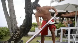 Atlet Timnas Surfing Indonesia, I Made Pajar Ariana, mengoleskan wax pada papan selancarnya sebelum menjalani sesi latihan di Pantai Berawa, Kuta Utara, Selasa (15/9/2026). Persiapan tersebut dilakukan sebagai bagian dari pematangan fisik dan teknik Pajar sebelum tampil pada Asian Games 2026 di Aichi-Nagoya, Jepang. (Bola.com/Alit Binawan)