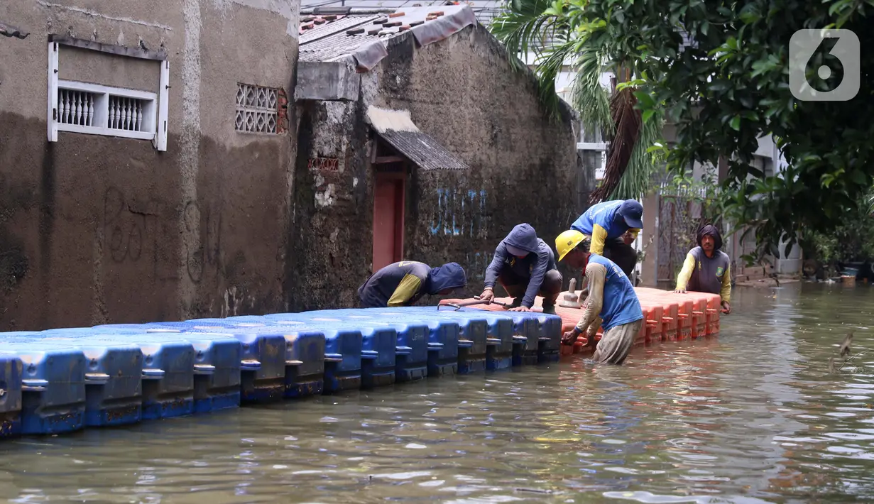 Petugas membuat jembatan apung saat banjir melanda Perumahan Periuk Damai, Tangerang, Banten, Selasa (23/2/2021). Adanya jembatan apung mempermudah warga saat melintasi banjir setinggi 2,5 meter di tempat tersebut. (Liputan6.com/Angga Yuniar)