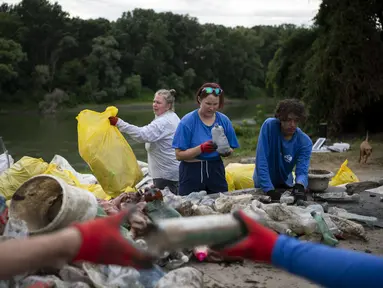 Para sukarelawan menyortir sampah yang terkumpul setelah mereka tiba di lokasi perkemahan pada hari Selasa, 1 Agustus 2023. (AP Photo/Denes Erdos)