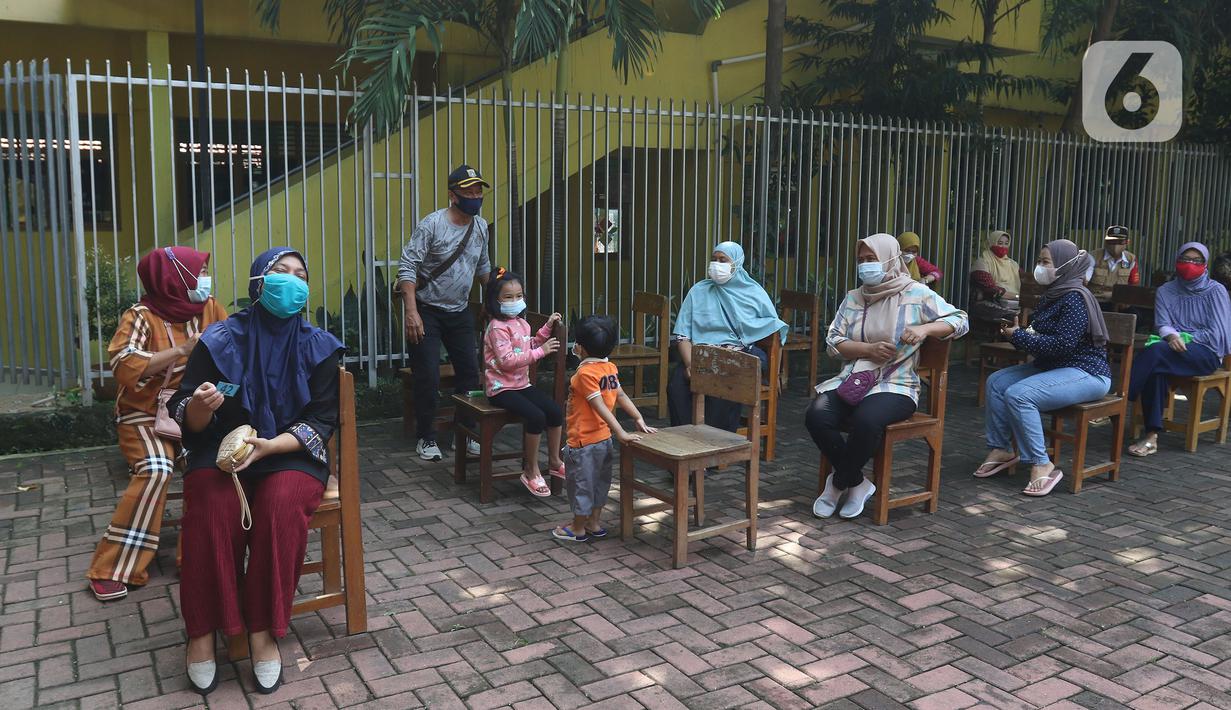 Sejumlah warga menunggu untuk divaksin di MTs As-Syafiiyah, Cilangkap, Jakarta, Kamis (3/6/2021).  Vaksinasi massal bagi warga RT 03/RW 03 Cilangkap, Cipayung, Jakarta Timur menggunakan vaksin produksi AstraZeneca. (Liputan6.com/Herman Zakharia)