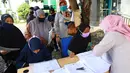 Warga antre menerima Bantuan Sosial Tunai (BST) di Kelurahan Pondok Benda, Kecamatan Pamulang, Tangerang Selatan, Minggu (10/01/2021). BST senilai Rp300 ribu akan disalurkan selama empat bulan berturut-turut mulai dari Januari - April 2021. (Liputan6.com/Fery Pradolo)