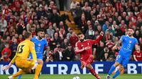 Penyerang Liverpool, Mohamed Salah (tengah), mencetak gol kedua timnya ke gawang kiper Atletico Madrid asal Slovenia, Jan Oblak, dalam pertandingan putaran pertama Liga Champions UEFA antara Liverpool dan Atletico Madrid di Anfield, Kamis (17/9/2025). (AFP/Oli Scarff)