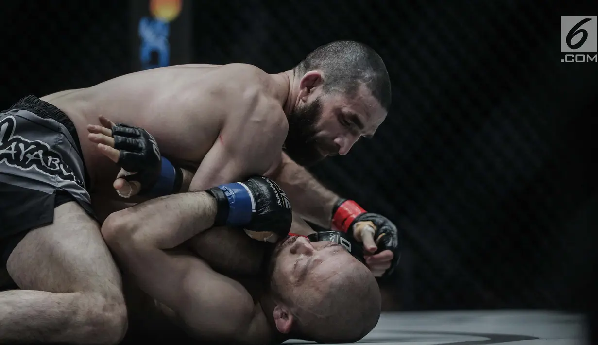 Petarung Rusia, Yusup Saadulaev (atas) saling beradu jurus dengan petarung Jepang, Masakazu Imanari saat berlaga pada One Championship di Jakarta Convention Center, Sabtu (20/1). Pertarungan dimenangkan oleh Yusup Saadulaev. (Liputan6.com/Faizal Fanani)