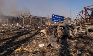 Pemandangan sebuah mobil yang hancur di tengah bangunan-bangunan yang rusak, serta rambu jalan yang menunjukkan arah dan jarak ke Kyiv dan Zhytomyr, setelah serangan Rusia menghantam sebuah gudang yang kemudian disusul oleh ledakan di desa Myla, wilayah Kyiv, Ukraina, Sabtu, 29 Agustus 2026. (Foto AP/Dan Bashakov)