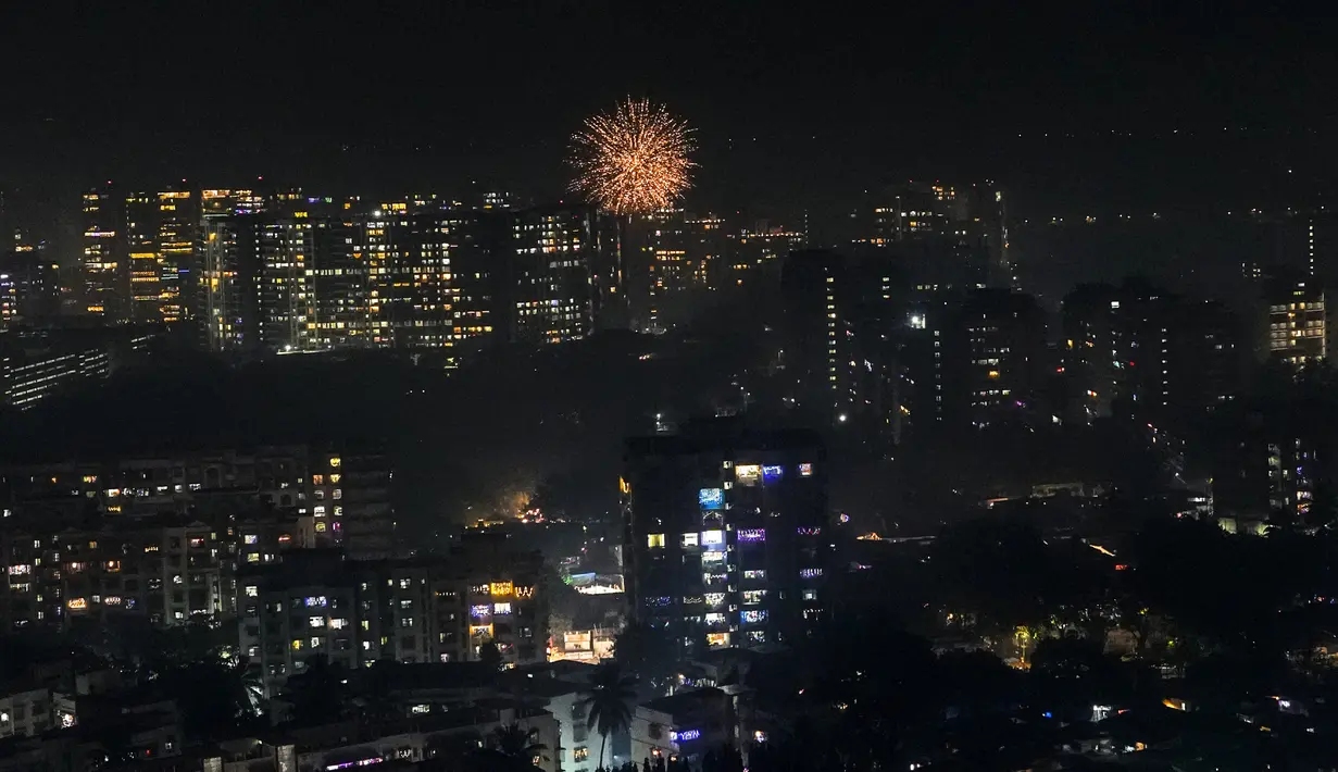 Bangunan perumahan dihiasi dengan lampu warna-warni, saat petasan menyala selama Diwali, festival lampu di Mumbai, India, Senin (24/10/2022). Orang India di seluruh negeri merayakan Diwali, festival Hindu yang melambangkan kemenangan cahaya atas kegelapan. (AP Photo/Rafiq Maqbool)