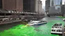 Petugas menggunakan kapal untuk menyemprotkan pewarna  hijau khusus ke sungai Chicago pada peringatan hari Santo Patrick di Illinois, Sabtu (17/3). Sungai itu setiap tahun mengalami perubahan warna demi memikat wisatawan. (Scott Olson/Getty Images/AFP)