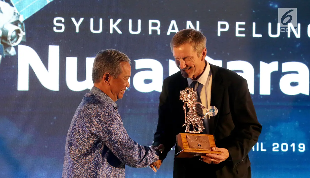Dirut PT Pasifik Satelit Nusantara Adi Rahman Adiwoso memberikan cindermata kepada Chief Operation Officer SSL, Paul Estey pada acara Syukuran Peluncuran Satelit Nusantara Satu di Jakarta, Senin (1/4). Syukuran digelar sebagai wujud rasa syukur keberhasilan mengorbit. (Liputan6.com/Fery Pradolo)