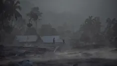 Orang-orang berjalan melewati rumah-rumah menyusul letusan gunung berapi oleh Gunung Semeru di desa Kajar Kuning di Lumajang (5/12/2022). Gunung Semeru meletus pada tanggal 4 Desember memuntahkan awan abu panas setinggi satu mil dan sungai lava di sisinya sambil memicu evakuasi hampir 2.000 orang tepat satu tahun setelah letusan besar terakhirnya menewaskan puluhan orang. (AFP/Juni Kriswanto)