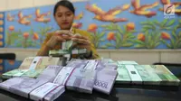 Teller menghitung uang pecahan kecil di kantor cabang Bank BJB di Melawai, Jakarta (7/6). Mengantisipasi kebutuhan dana masyarakat di bulan Ramadan dan Lebaran, pemerintah telah mengalokasikan uang tunai sebesar Rp 188,2 Triliun. (Merdeka.com/Arie Basuki)