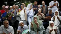  Warga berdoa di dekat truk yang membawa 136 peti mati korban pembantaian Srebrenica juli, 1995, di desa Visoko, Bosnia-Herzegovina, Kamis, (9/7/2015). Pasukan Serbia Bosnia dibantai, 8.000 etnis Muslim wafat pada waktu itu. (REUTERS/Stoyan Nenov)