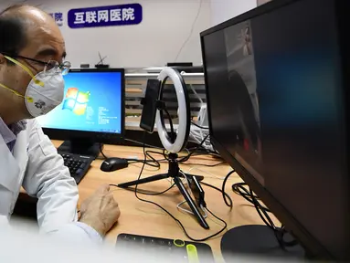 Petugas medis Rumah Sakit Umum Universitas Kedokteran Tianjin melakukan pemeriksaan daring via ponsel di Tianjin, 3 Maret 2020. RS itu meluncurkan pemeriksaan dan pemberian resep secara daring serta pengiriman obat untuk membantu mencegah kemungkinan infeksi silang virus corona. (Xinhua/Li Ran)