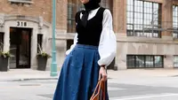 Cocok untuk outfit kerja, padukan blouse putih dengan vest hitam, dan rok jeans a-line ala selebgram Turki Elif Dogan ini. (Instagram/elifd0gan).