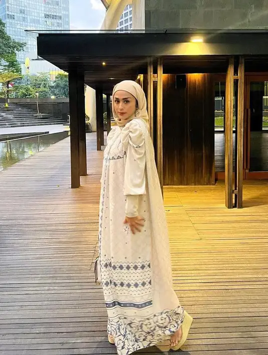 Gamis panjangnya dipadukan dengan hijab dan aksesori warna senada. (Instagram/selvikitty).