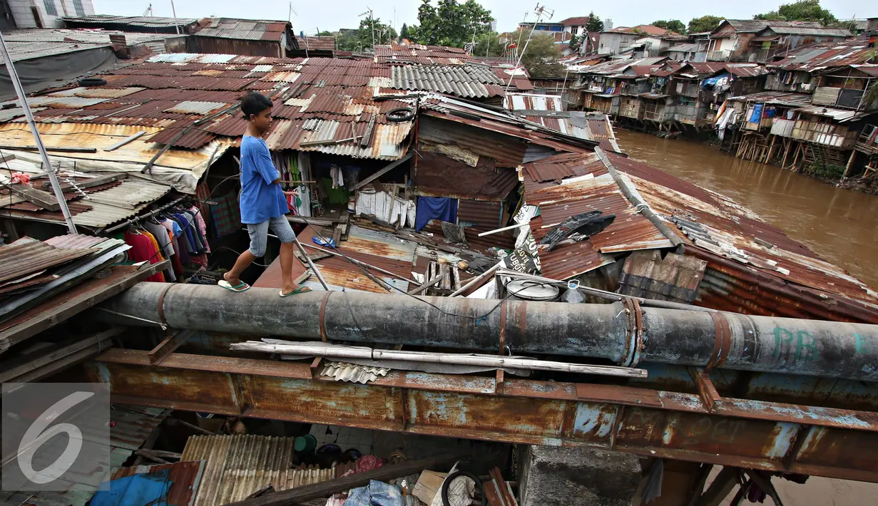 Warga saat ingin menyebrangi bantaran Kali Ciliwung, Jakarta, Rabu (20/1). Apabila rusun yang disediakan telah siap ditempati Pemprov DKI Jakarta akan melakukan penggusuran pemukiman kumuh sebanyak mungkin. (Liputan6.com/Immanuel Antonius)
