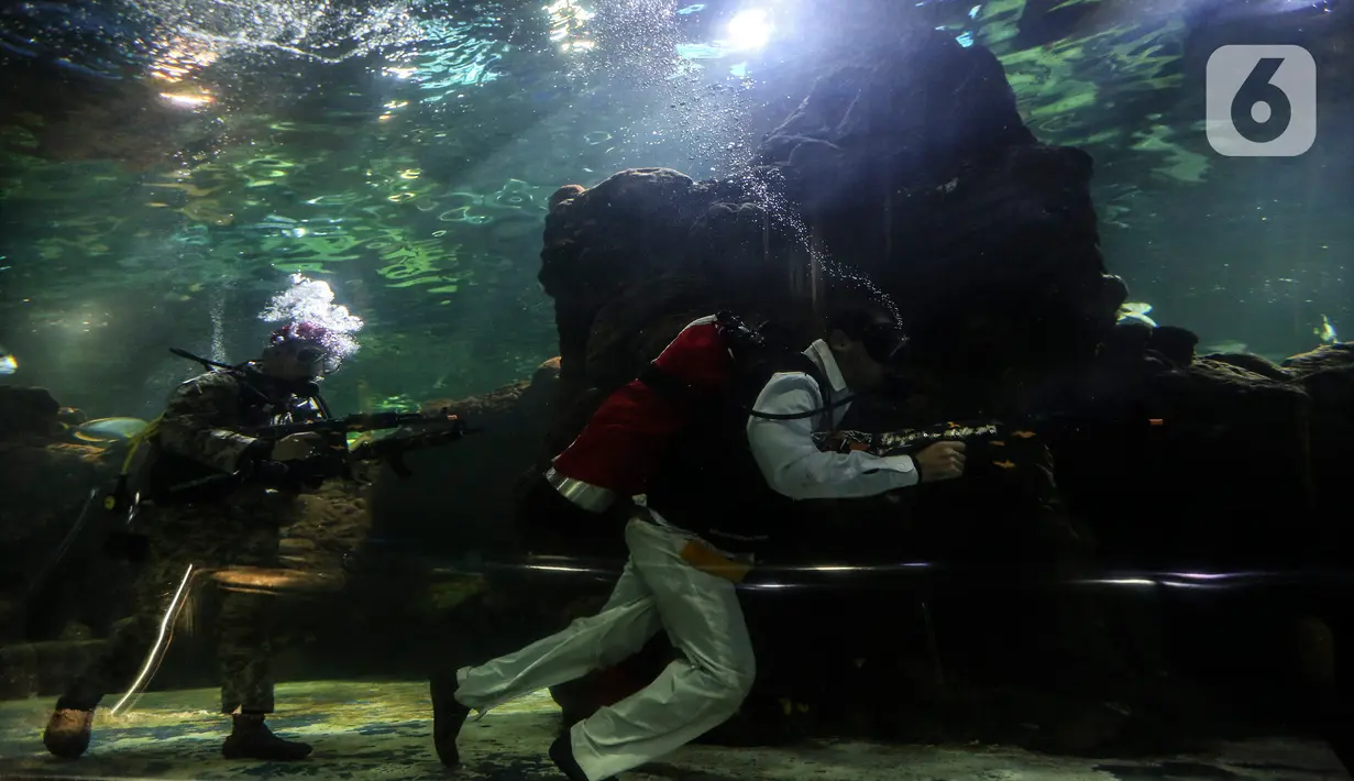 Penyelam mementaskan drama teatrikal yang bertajuk "Semangat perjuangan" di akuarium utama Sea World, Ancol, Jakarta, Selasa (10/11/2020). Pertunjukan dengan latar belakang Pertempuran Surabaya itu digelar pada 7-10 November untuk memperingati Hari Pahlawan Nasional. (Liputan6.com/Johan Tallo)