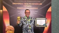 Wali Kota Cilegon Helldy Agustian menunjukkan penghargaan Cakupan Kesehatan Semesta atau Universal Health Coverage (UHC) Kategori Madya.