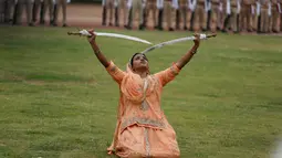 Seorang wanita India beraksi menggunakan dua pedang selama perayaan hari Kemerdekaan di Ahmadabad, India, (15/8). India merdeka dari kolonialis Inggris pada tahun 1947. (AP Photo / Ajit Solanki)