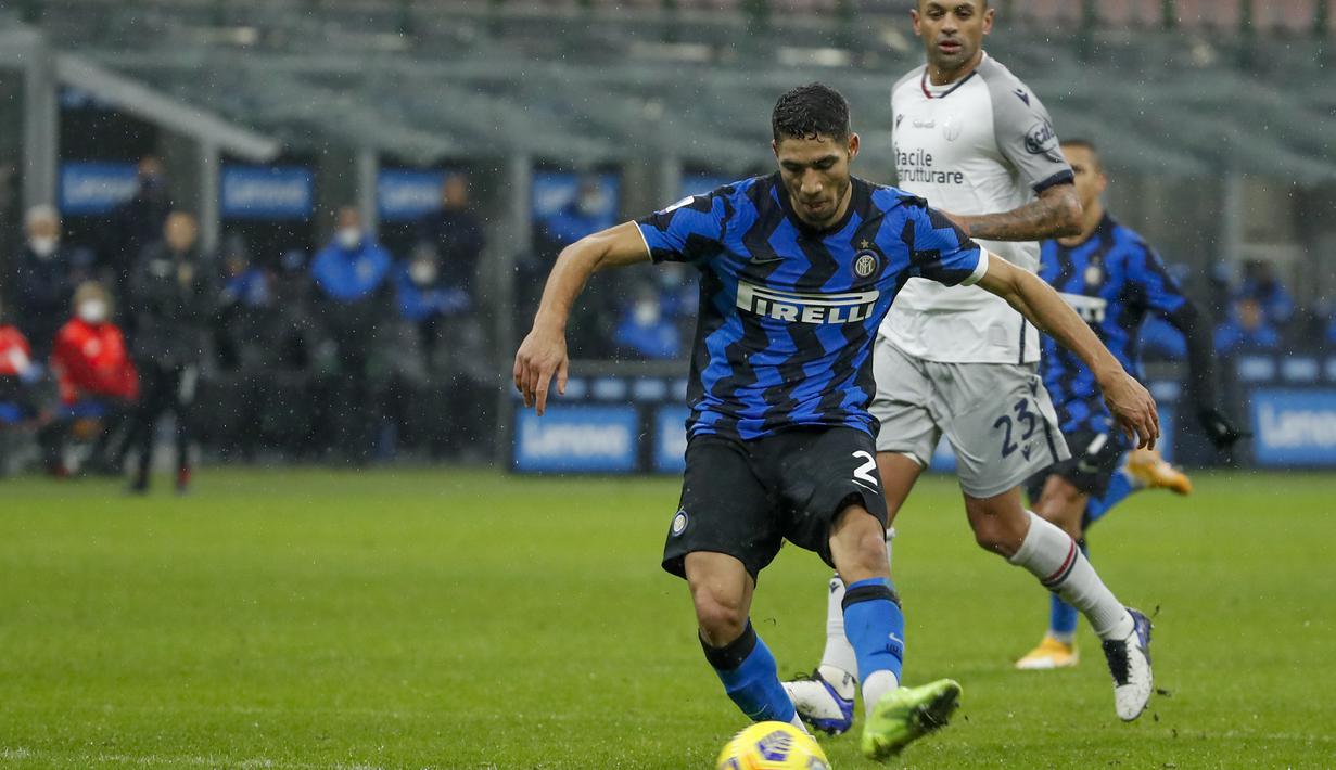Gelandang Inter Milan, Achraf Hakimi, melepaskan tendangan yang berbuah gol keduanya dalam laga lanjutan Liga Italia Serie A pekan ke-9 melawan Bologna di San Siro Stadium, Sabtu (5/12/2020). Inter milan mengalahkan Bologna 3-1. (AP/Antonio Calanni)