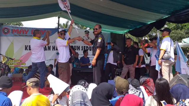 Nampak panitia senam May Day tengah memberikan sebuah hadiah bagi buruh yang beruntung mendapatakannya, pada perayaan May Day hari ini