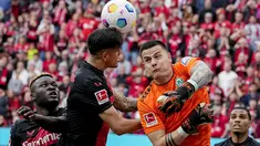 Pemain Victor Boniface dan Piero Hincapie serta kiper Werder Bremen Michael Zetterer berebut bola pada pertandingan Liga Jerman (Bundesliga) 2023-2024 di Stadion BayArena, Leverkusen, Minggu (14/4/2024). (AP Photo/Martin Meissner)