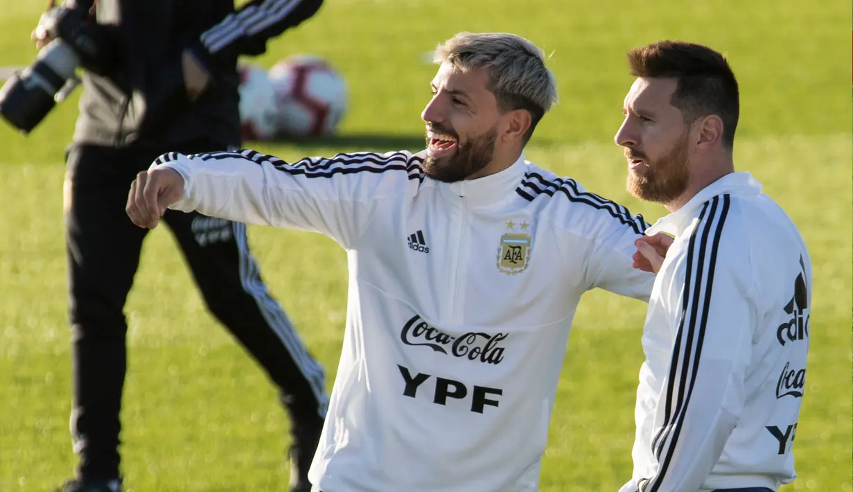 Penyerang Argentina, Lionel Messi berbincang dengan rekannya Sergio Aguero saat mengikuti sesi latihan tim jelang bertanding melawan Brasil di Ciudad Deportiva Antonio Asensio di Palma de Mallorca (12/11/2019). (AFP/Jaime Reina)