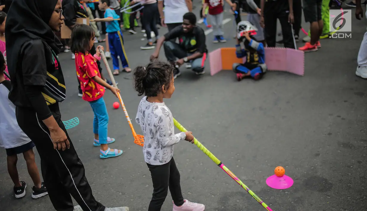 Anak-anak bermain permainan tradisional ditemani sejumlah mahasiswa dari Penggerak Olahraga saat car free day (CFD) di kawasan Bundaran HI, Jakarta, Minggu (14/7/2019). Kegiatan yang rutin digelar ini bertujuan mengajak masyarakat DKI Jakarta aktif berolahraga. (Liputan6.com/Faizal Fanani)