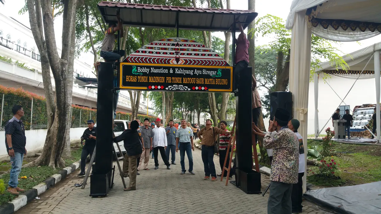 Para pekerja dan panitia tampak sibuk merampungkan berbagai dekorasi yang sudah didesain dengan corak adat Sumatera Utara (Liputan6/Nanda Perdana Putra)