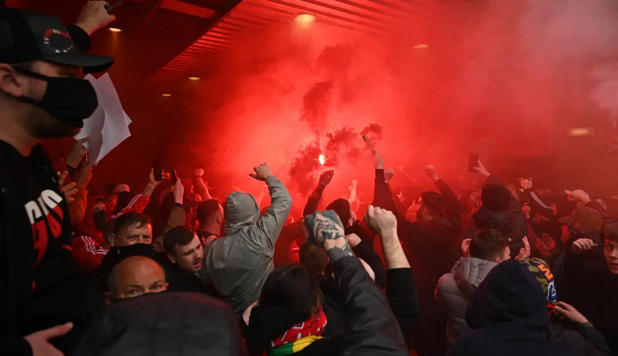 Ribuan suporter Manchester United mencoba untuk memaksa masuk ke dalam stadion Old Trafford saat mereka memprotes keluarga Glazer menjelang pertandingan Liga Premier Inggris melawan Liverpool. (Foto: AFP/Oli Scarff)