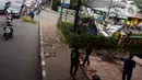 Kondisi lalu lintas saat petugas pemadam kebakaran memotong rangka reklame yang roboh di Jalan Soepomo, Jakarta, Sabtu (28/5/2022). Hujan disertai angin kencang pada pagi tadi membuat papan reklame roboh sehingga membuat kemacetan arus lalu lintas di jalan tersebut. (merdeka.com/Imam Buhori)