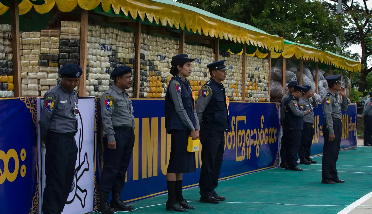 Sejumlah perwira polisi berjaga dekat narkotika sitaan sebelum acara pemusnahan pada Hari Antinarkoba Sedunia, di Yangon, Senin (26/6). Myanmar membakar opium, heroin, dan kokain senilai sekitar US$385 juta, setara Rp5,1 miliar. (AP Photo/Thein Zaw)