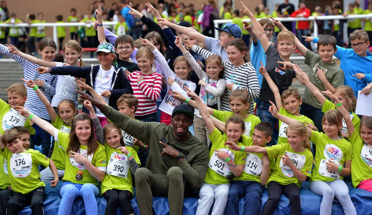 Sprinter asal Jamaica, Usain Bolt berfoto bersama anak-anak yang ikut dalam lomba lari  di Prague, Republik Ceska, (18/5/2016). (AFP/Michal Cizek)