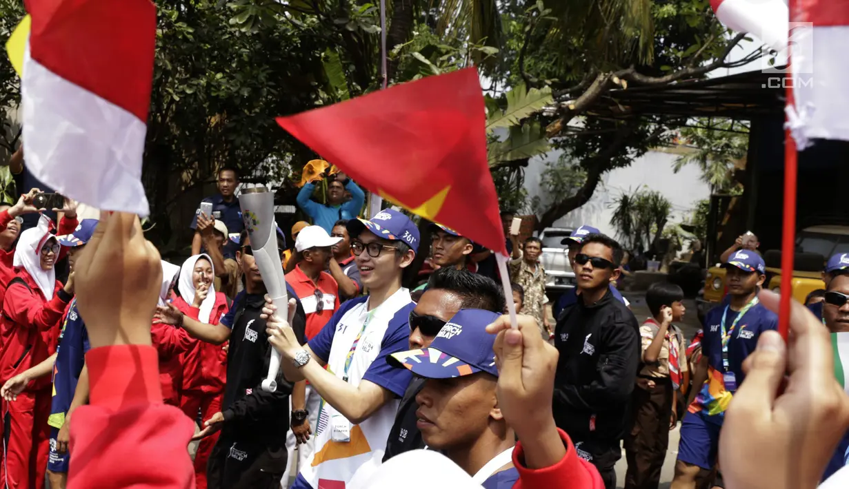 Aktor Brandon Salim membawa obor Asian Games saat Torch Relay Asian Games 2018 di Cipayung, Jakarta Timur, Rabu (15/8). Ini kali pertama api abadi kembali ke Jakarta setelah terakhir singgah pada Asian Games 1962. (Kapanlagi.com/Agus Apriyanto)