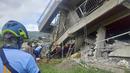 Tim penyelamat mencoba menarik seorang warga yang terperangkap dari bawah reruntuhan bangunan setelah gempa kuat melanda La Trinidad, Provinsi Benguet, Filipina, 27 Juli 2022. Guncangan gempa menyebabkan banyak tembok rumah dan bangunan yang retak, termasuk beberapa runtuh. (Bureau of Fire Protection via AP)