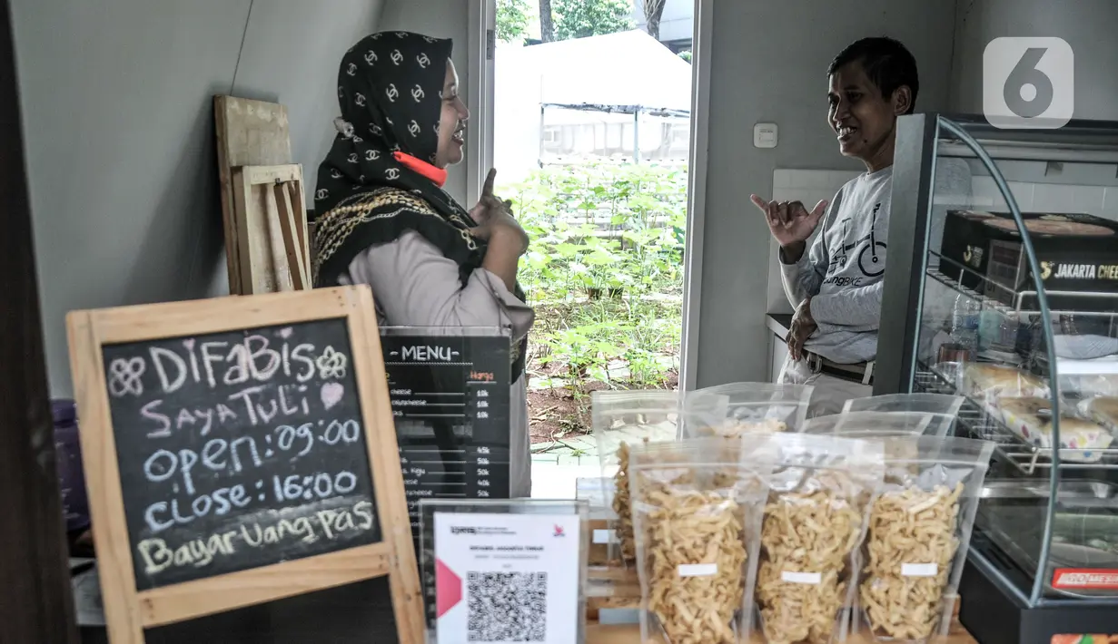 Pekerja yang merupakan penyandang tunarungu saat berbincang di Kafe Difabis Coffee & Tea, Kompleks Kantor Wali Kota Jakarta Timur, Senin (19/12/2022). Kafe yang didirikan oleh Baznas (Bazis) DKI Jakarta tersebut diharapkan dapat mengembangkan dan memaksimalkan peran dari Kafe Difabis yang dioperasikan oleh kawan-kawan difabel untuk memberikan pemahaman pada masyarakat dan kesetaraan. (merdeka.com/Iqbal S. Nugroho)