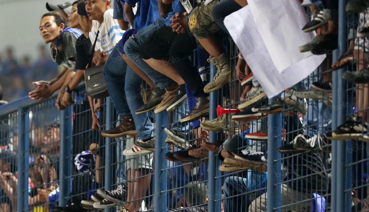 Suporter Persib Bandung berdiri diatas pagar pembatas saat memberikan dukungan kepada timnya melawan Persija Jakarta di Stadion Gelora Bandung Lautan Api, Bandung (16/7/2016). (Bola.com/Nicklas Hanoatubun)