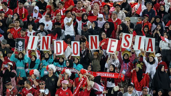 <p>Para suporter Indonesia memberi dukungan saat Timnas Indonesia U-23 menghadapi Yordania U-23 pada laga ketiga Grup A Piala Asia U-23 2024 di Abdullah bin Khalifa Stadium, Doha, Qatar, Minggu (21/4/2024). (AFP/Karim Jaafar)</p>
