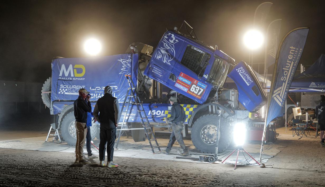 Sejumlah mekanik tim Solurent Racing tengah mempersiapkan mobil menjelang Reli Dakar 2025 pada Kamis (02/01/2025) waktu setempat di Bisha, Arab Saudi. Ajang tersebut akan berlangsung pada 3 hingga 17 Januari 2025. (AFP/Valery Hache)