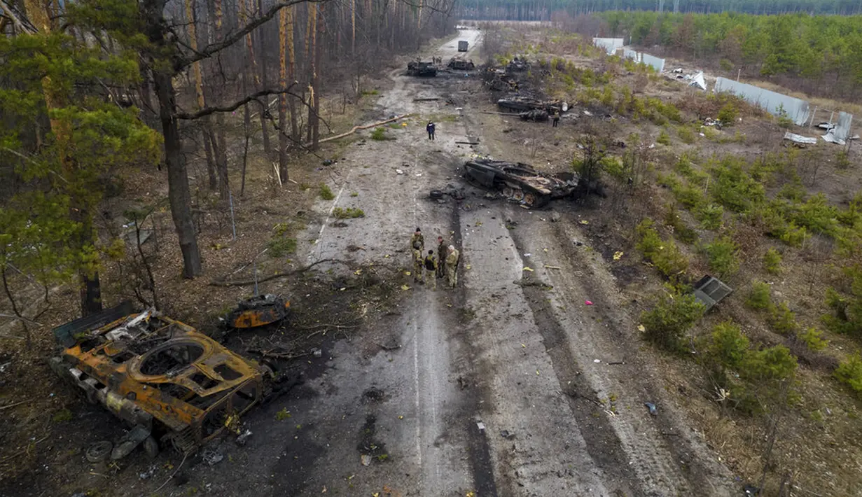 Tentara Ukraina berdiri di tengah kendaraan lapis baja Rusia yang hancur di pinggiran Kiev, Ukraina, 31 Maret 2022. Pasukan Rusia menembaki pinggiran Kota Kiev, dua hari setelah Kremlin mengumumkan akan secara signifikan mengurangi operasi dekat Ibu Kota dan Chernihiv. (AP Photo/Rodrigo Abd)