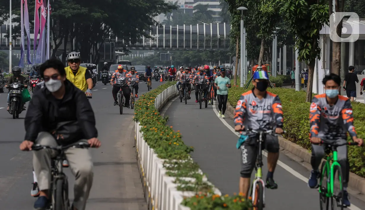 Sejumlah warga berolahraga melintas di kawasan Sudirman - Thamrin saat akhir pekan, Jakarta, Minggu (20/2/2022). Aktivitas warga di kawasan tersebut relatif ramai saat Pemberlakuan Pembatasan Kegiatan Masyarakat (PPKM) level tiga di ibu kota. (Liputan6.com/Johan Tallo)