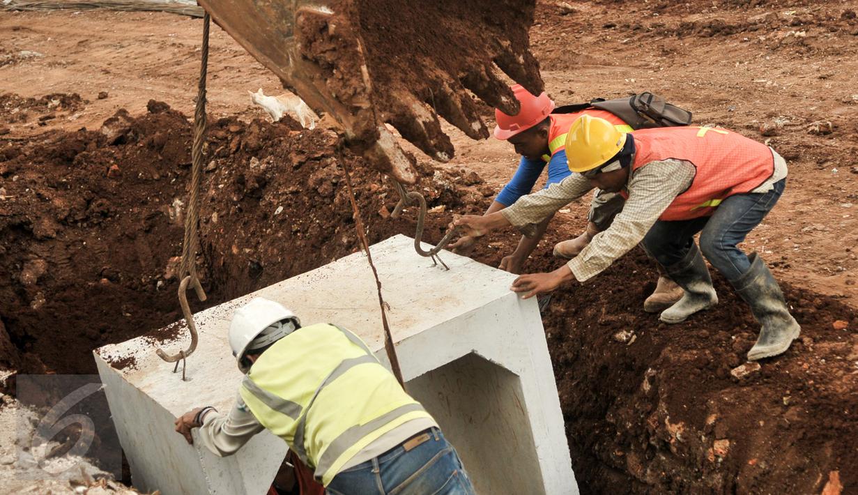 Pekerja memasang beton saluran air di proyek normalisasi Ciliwung, Bukit Duri, Jakarta, Rabu (8/2). Penyelesaian normalisasi Ciliwung mencakup pembangunan dinding parapet, sheetpile, jalan inspeksi maupun saluran air.(Liputan6.com/Yoppy Renato)