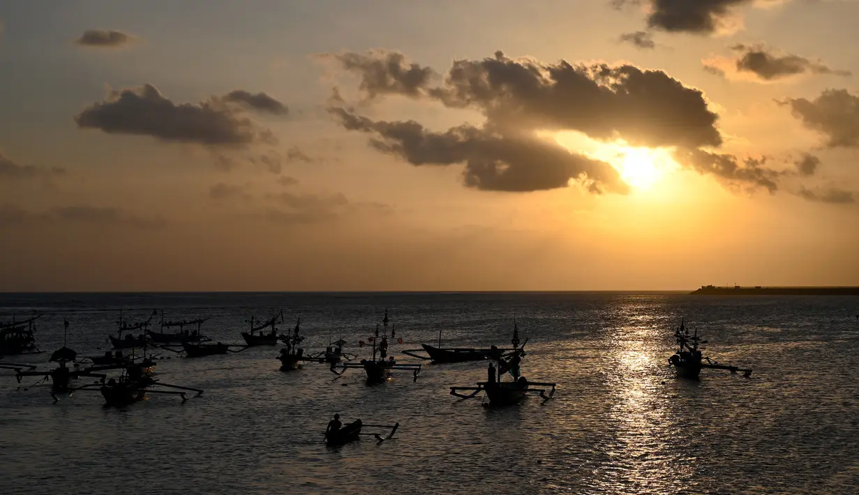 Nelayan mengayuh perahunya untuk pergi memancing ikan di Kedonganan, Denpasar, Bali (15/7/2019). Salah satu versi menyebutkan Kedonganan adalah sebuah desa yang sudah ada dari tahun 1324 (Saka warsa 1246) tetapi dengan nama Kedongayan. (AFP Photo/Sonny Tumbelaka)