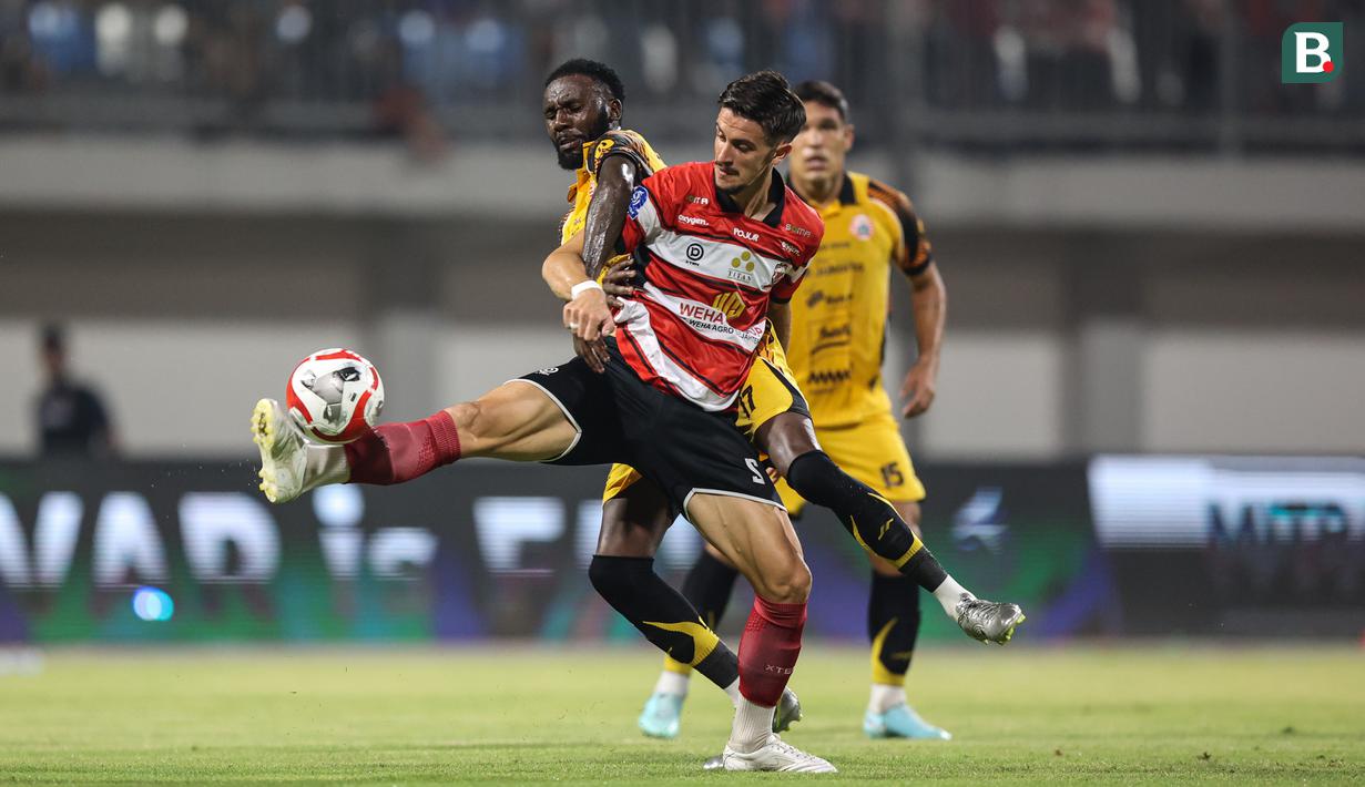 Pemain Madrura United, Kerim Palic (kanan) berduel dengan pemain Persija Jakarta, Allano Lima (kiri) pada lanjutan BRI Super League 2025/2026 di Stadion Gelora Ratu Pamelingan, Jumat (24/10/2025) malam WIB. (Bola.com/Abdul Aziz).