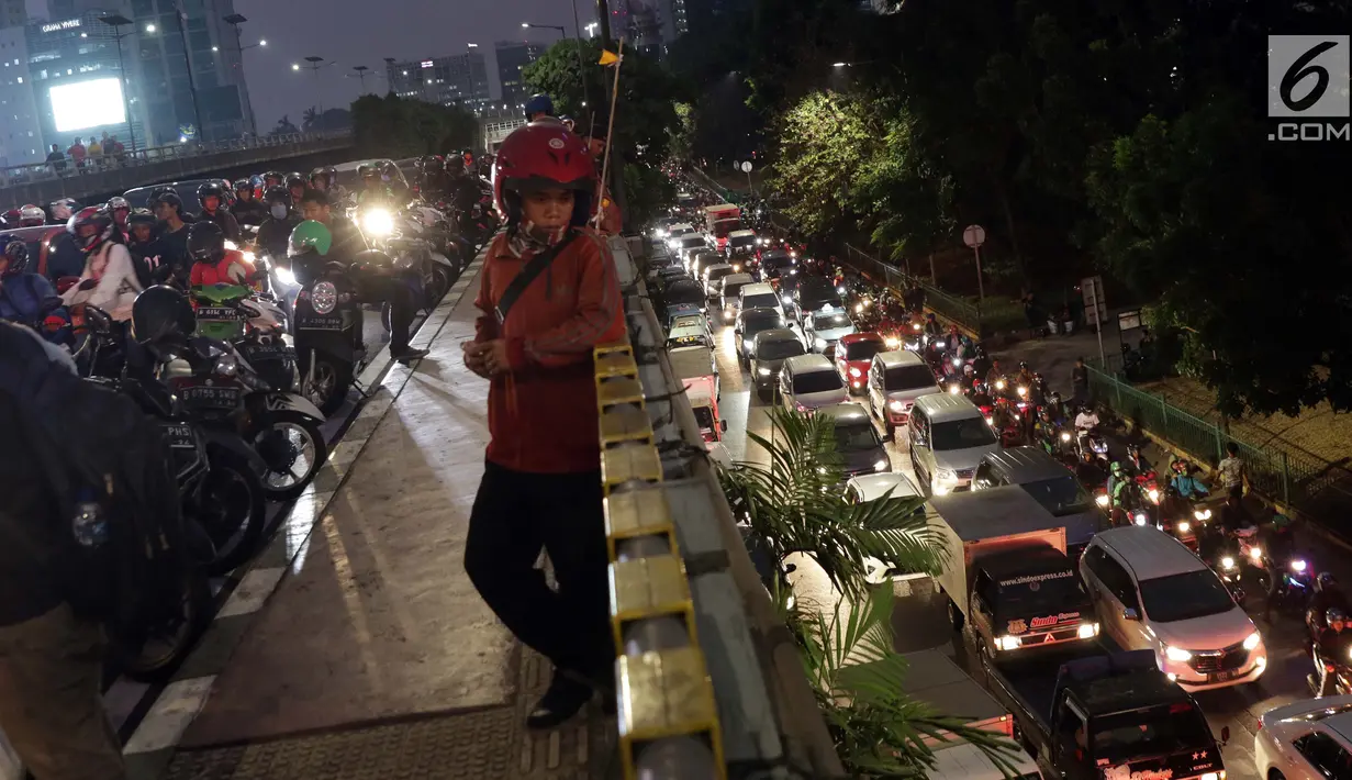 Warga melihat kendaraan yang terjebak kemacetan di sekitar kawasan Pejompongan akibat unjuk rasa mahasiswa di depan Gedung DPR, Jakarta, Selasa (24/9/2019). Demonstrasi mahasiswa dilakukan untuk menolak pengesahan berbagai RUU yang dianggap bermasalah. (Liputan6.com/Helmi Fithriansyah)