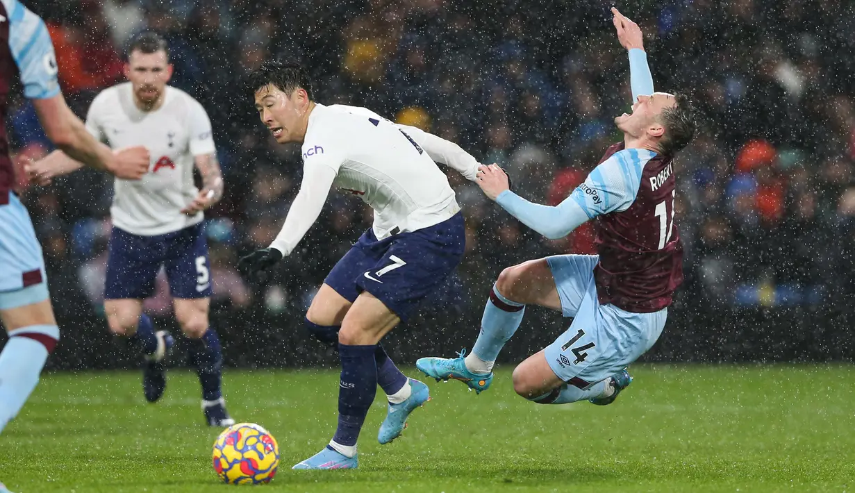 Penyerang Tottenham Hotspur, Son Heung-Min (kiri) berebut bola dengan bek Burnley, Connor Roberts pada pertandingan lanjutan Liga Inggris di Stadion Turf Moor, Inggris, Kamis (24/2/2022). Burnley menang tipis atas Tottenham 1-0. (AFP/Nigel Roddis)