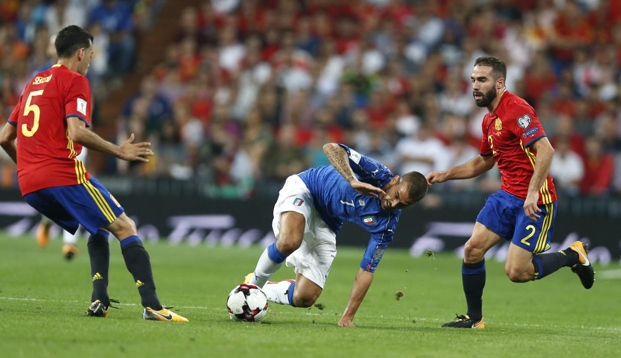 Pemain Italia, Leonardo Spinazzola (tengah) mencoba melewati adangan pemain Spanyol pada  laga Grup G kualifikasi Piala Dunia 2018 di Santiago Bernabeu stadium, Madrid, (2/9/2017). Spanyol menang 3-0. (AP/Francisco Seco)