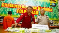 Direktur Reserse Narkoba Polda Riau Kombes Suhirman memperlihatkan barang bukti sabu yang disita dari dua tersangka. (Liputan6.com/M Syukur)
